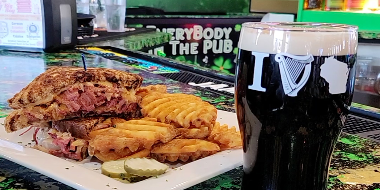 Reuben sandwich with waffle fries and a pint of Guinness.
