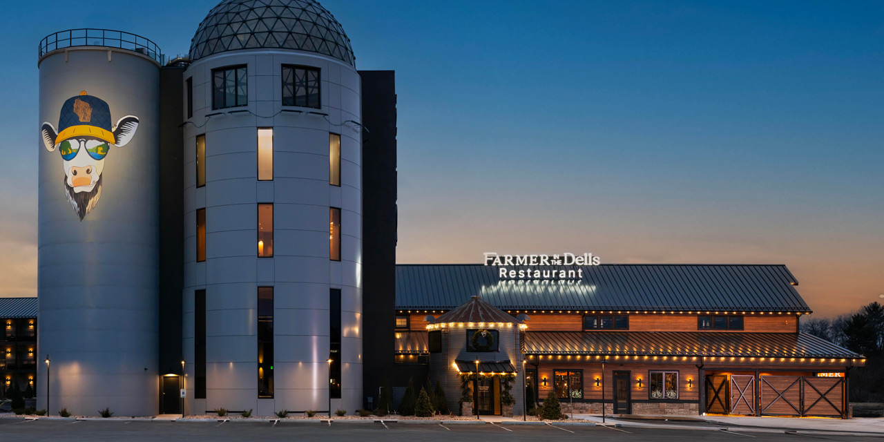 Silo shaped buildings with a cow mural.