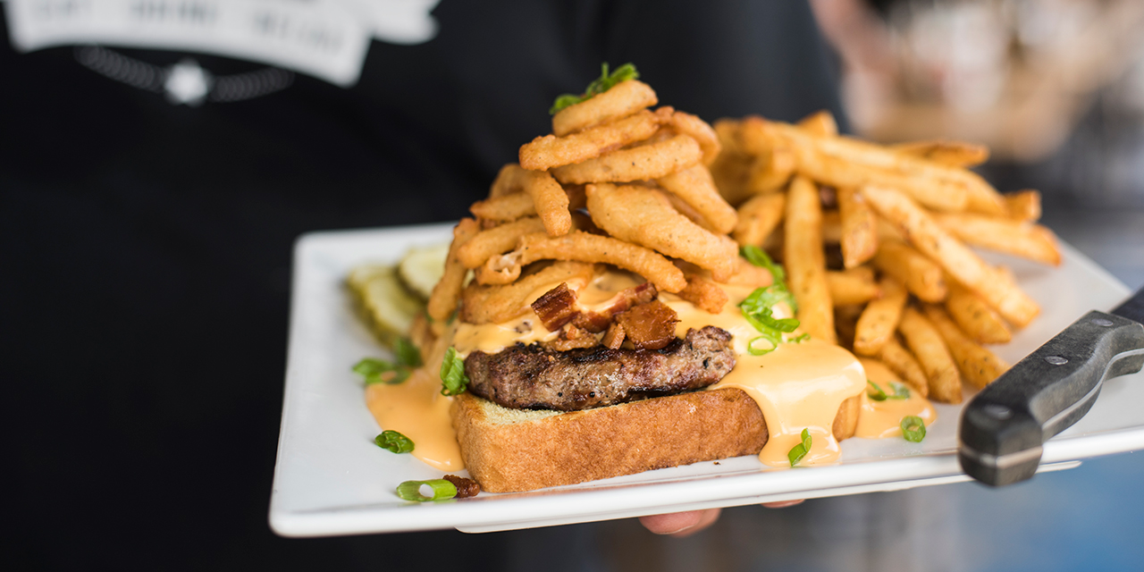 A loaded sandwich with french fries.