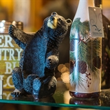 A bear bottle holder and decorative wine glasses.