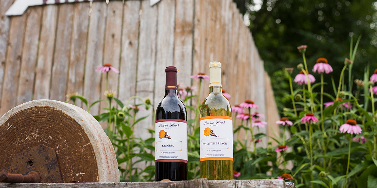 Two bottles of wine in a nice outdoor setting.